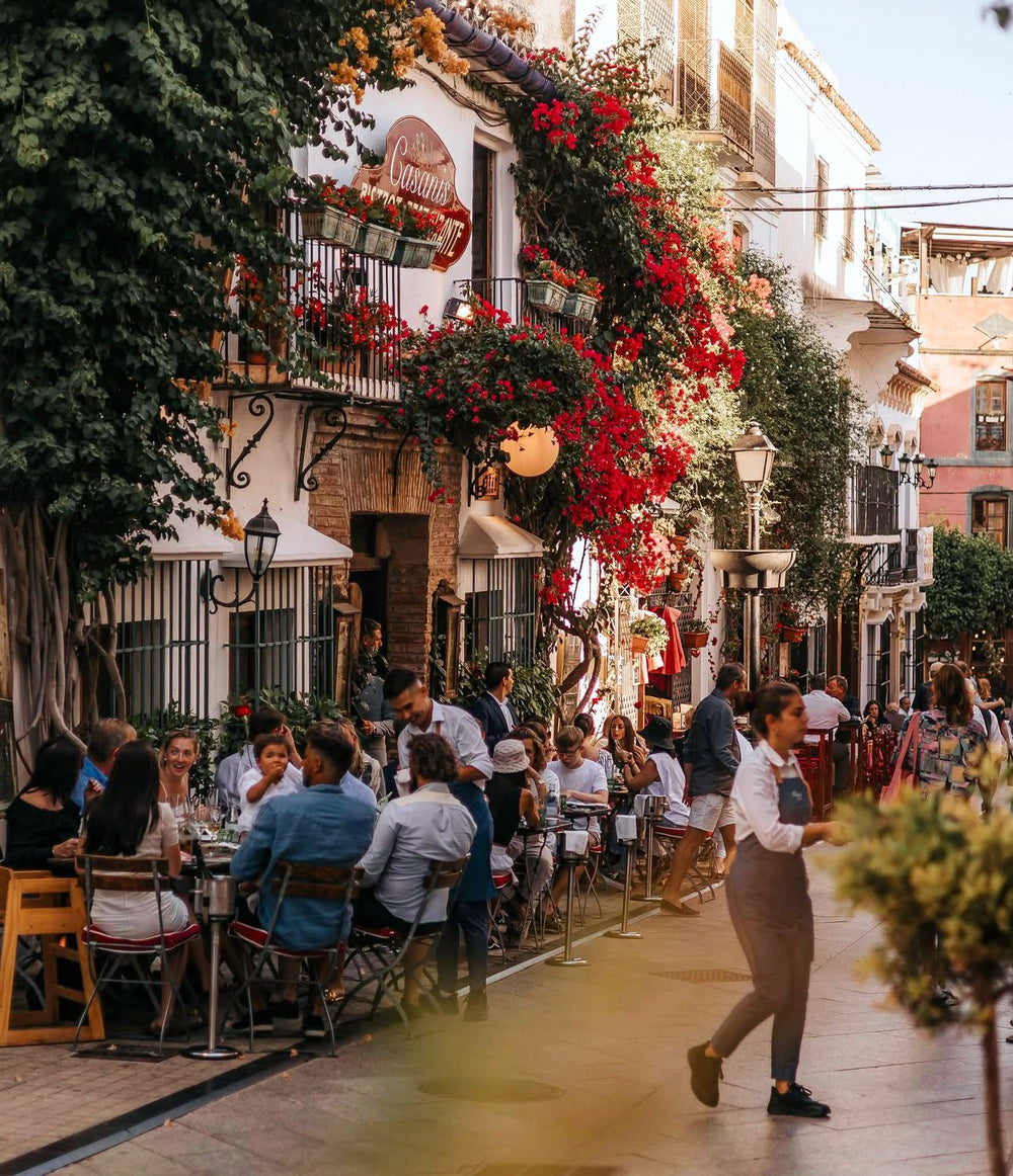 Diners at outdoor tables under bougainvillea outside Casanis Bistrot in Marbella Old Town