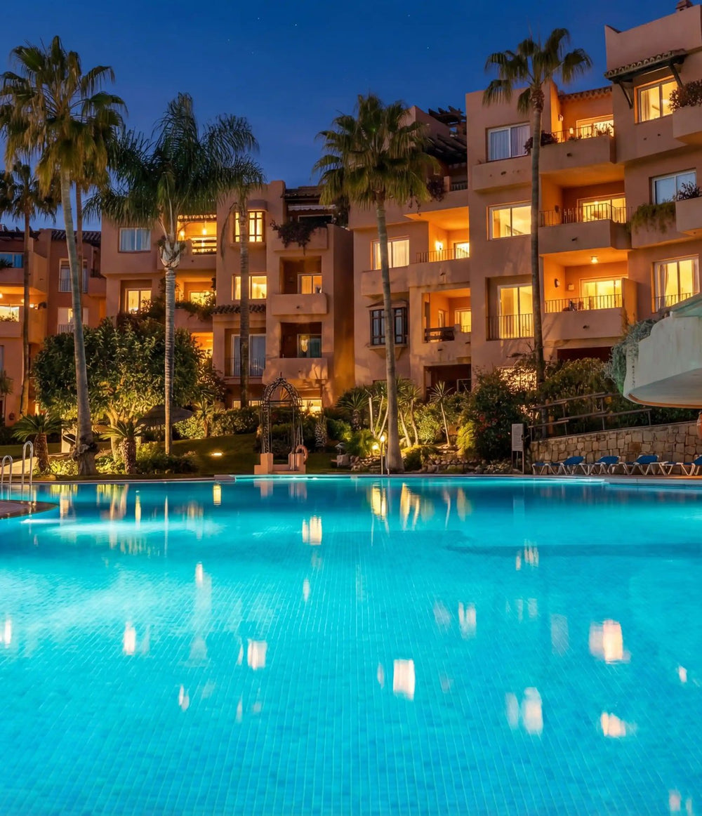 Pool lit at dusk among palms in a Golden Mile residence, Marbella