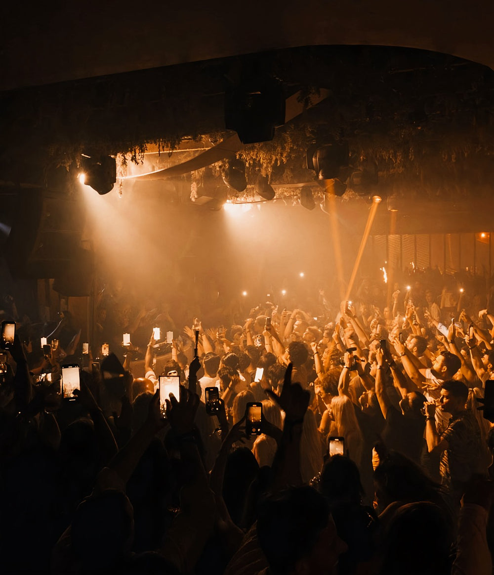 Crowd under golden stage lights at Momento nightclub, Marbella