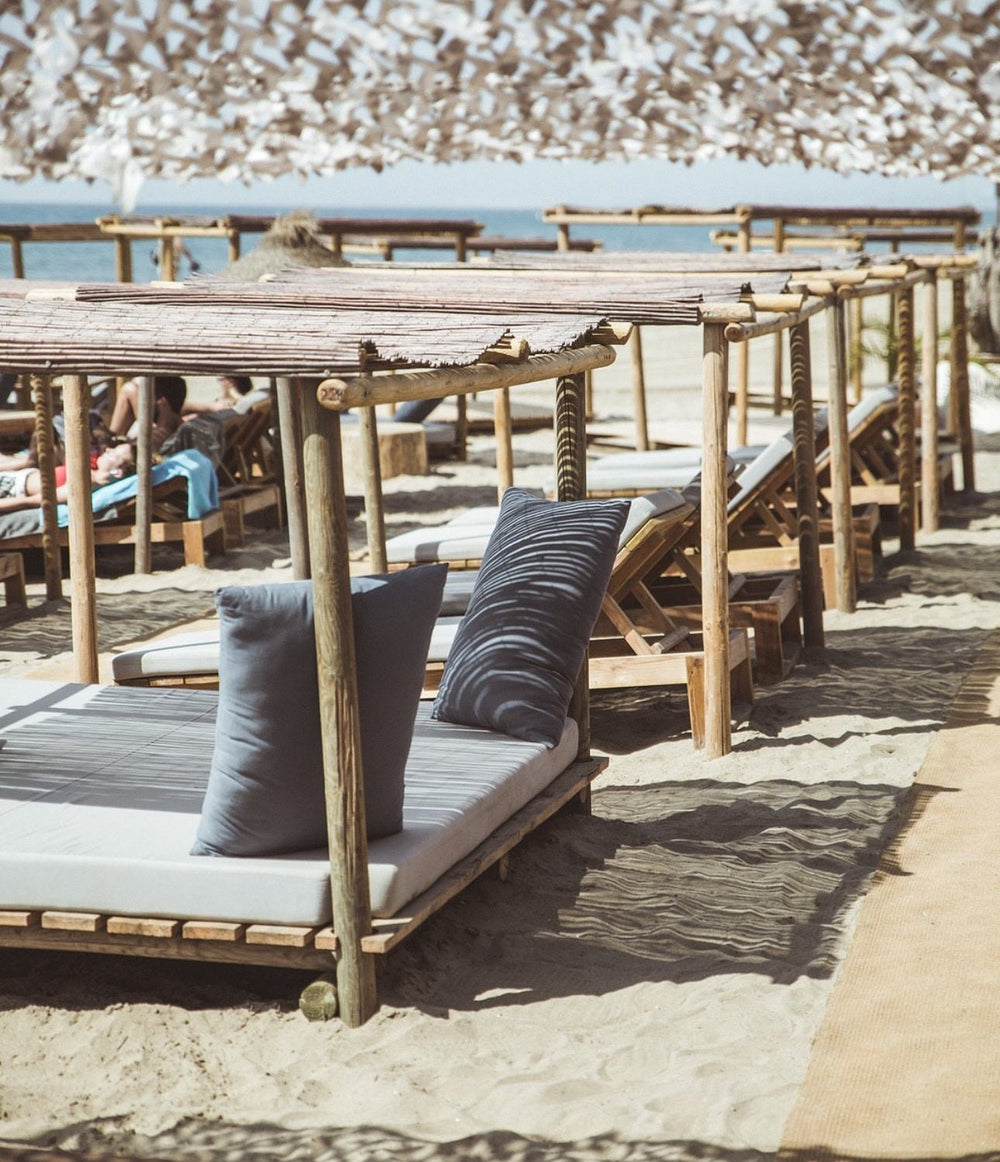 Shaded Bali beds on the sand at La Plage Casanis beach club, Marbella