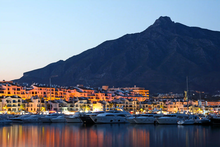 Sunset over the Marbella marina with yachts moored beneath La Concha mountain